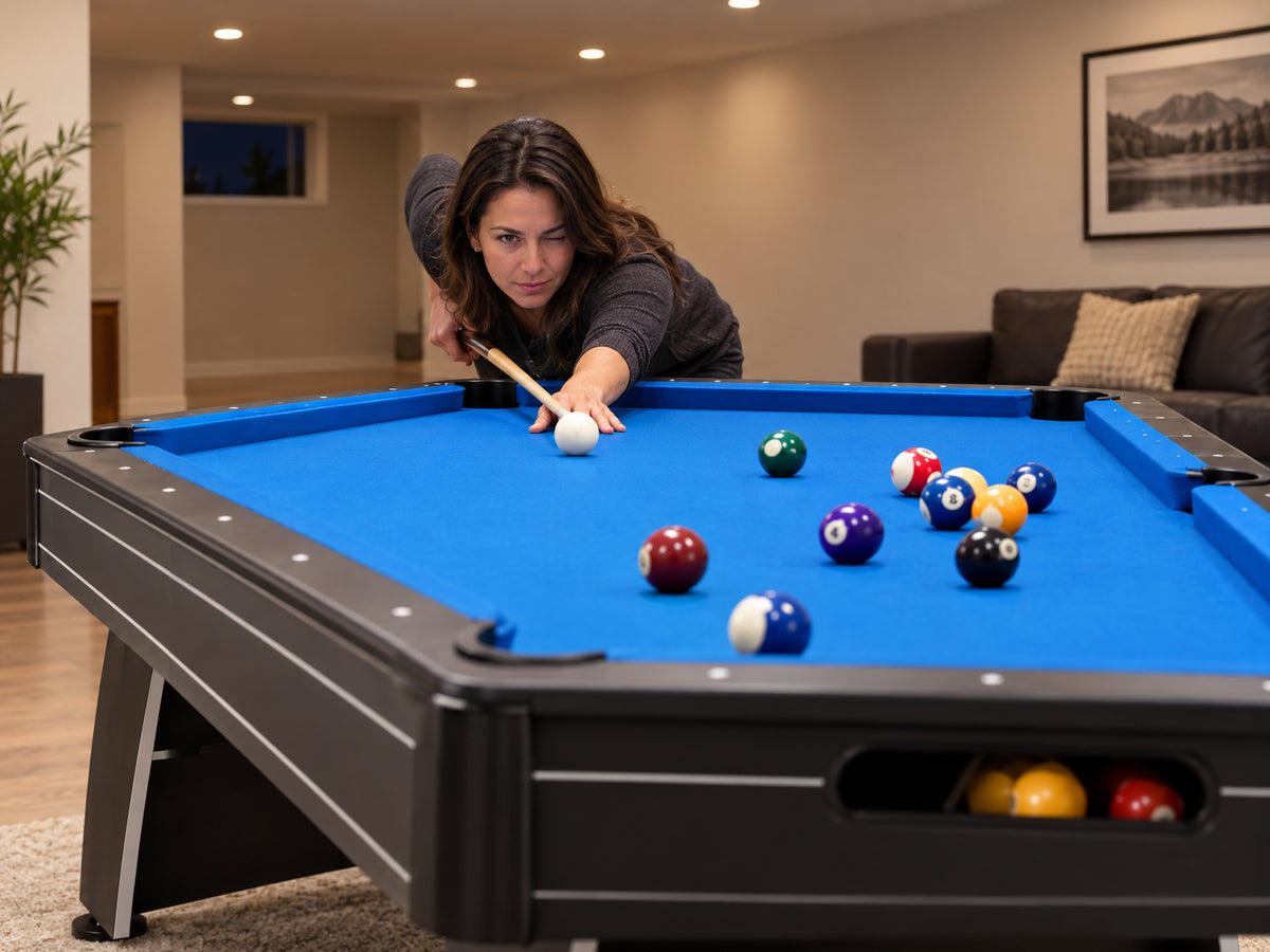 Pool Table Built, a woman crouching low at one end, eye level with the blue surface