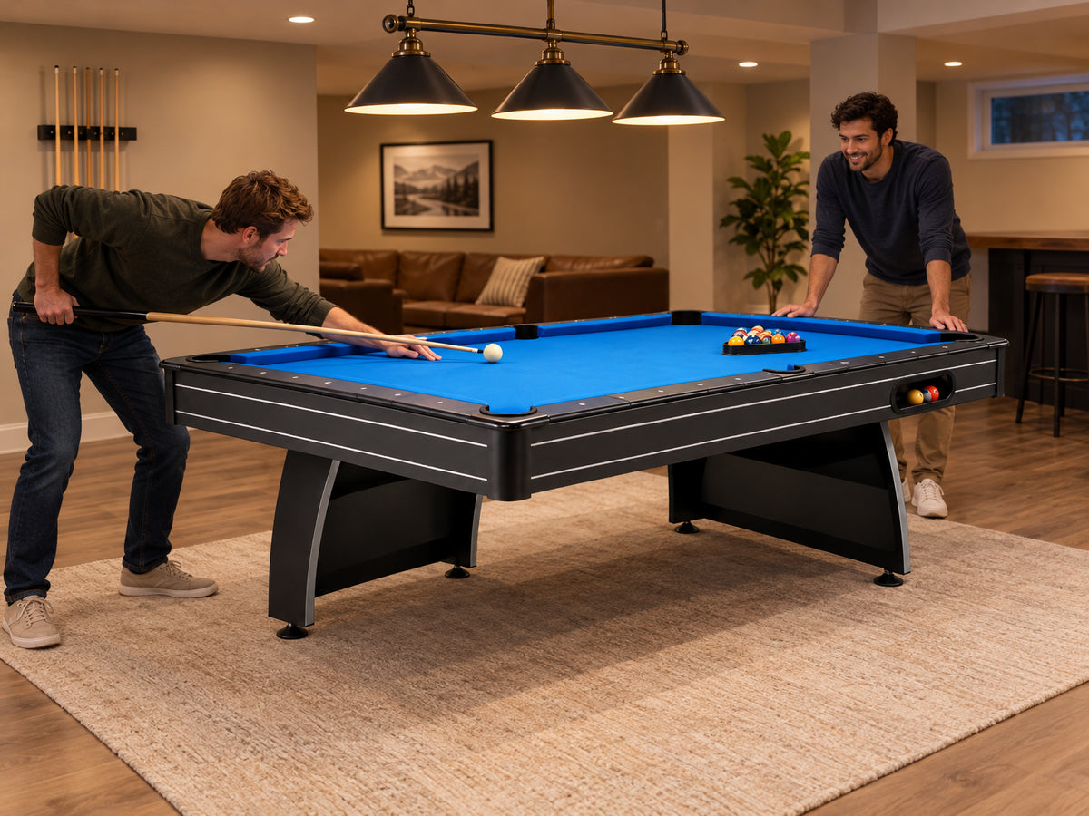Pool Table Built, two friends leaning over opposite ends of the table, one mid-stroke on a break shot